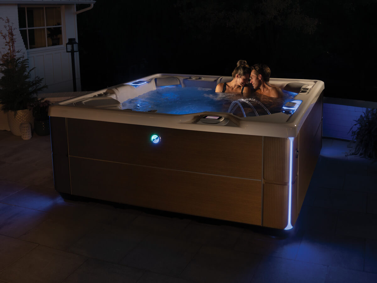 Couple relaxing in a hot tub at night